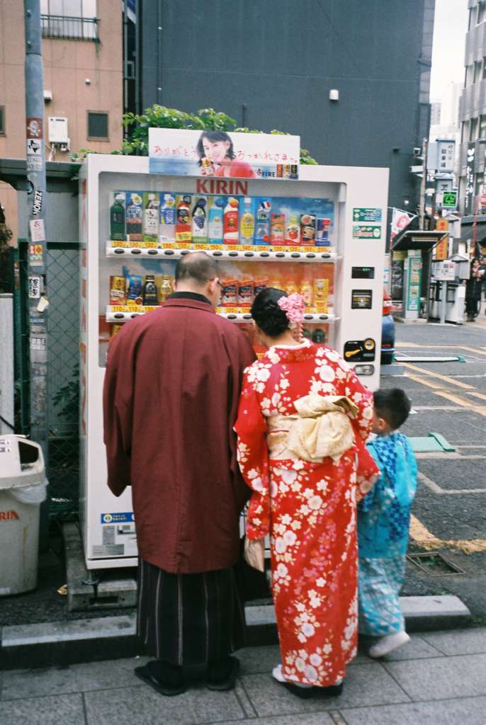 A family in traditional Japanese dress buy drinks from a vending machine in Tokyo, snapped by a student on an Astray writing workshop in Japan.